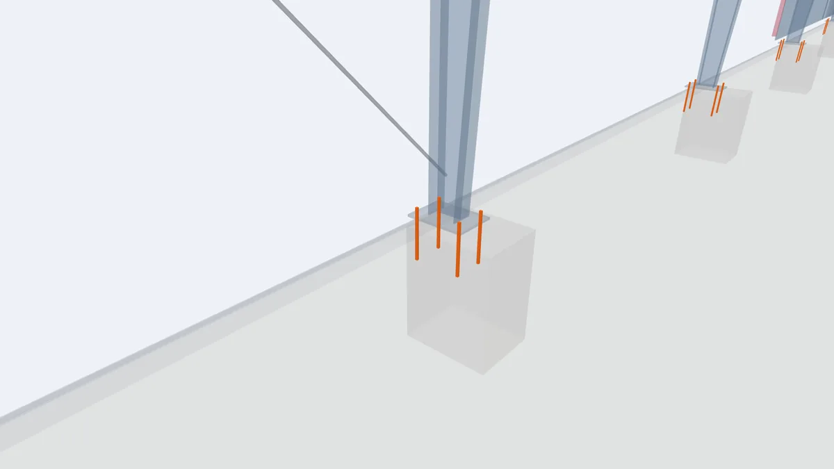 Close-up of four anchor bolts projecting from a concrete footing under a column base plate in the PEB model